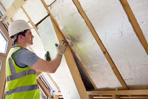 Builder installing insulation in new home