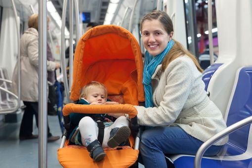 Young mum and toddler in a pushchair on a train